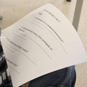 Zbliżenie kartki z ćwiczeniem „Moje źródła siły” z pytaniami; kartka leży na kolanach uczestnika.