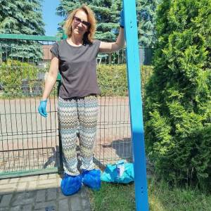 Uczestniczka prezentuje świeżo pomalowany element przeznaczony do odnowienia Ławki Dobrych Słów