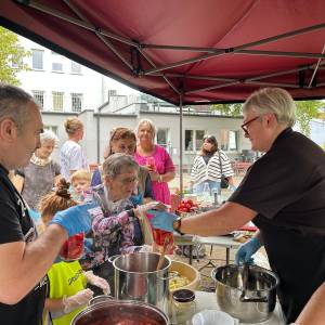 Uczestnicy warsztatów przygotowują pomidorowe przetwory pod namiotem Centrum Usług Społecznych w Swarzędzu.